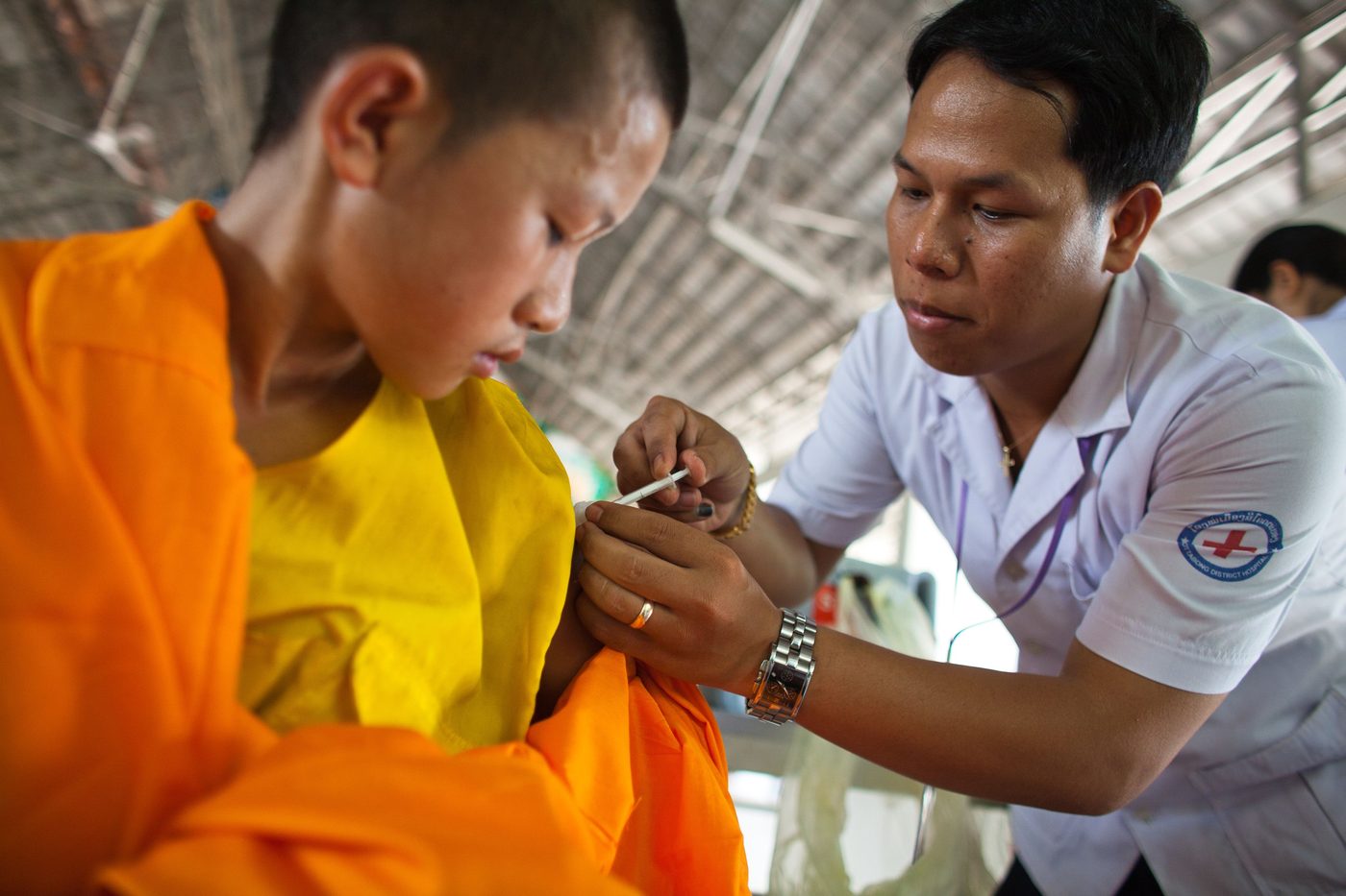 A health worker administering a vaccine to a young person